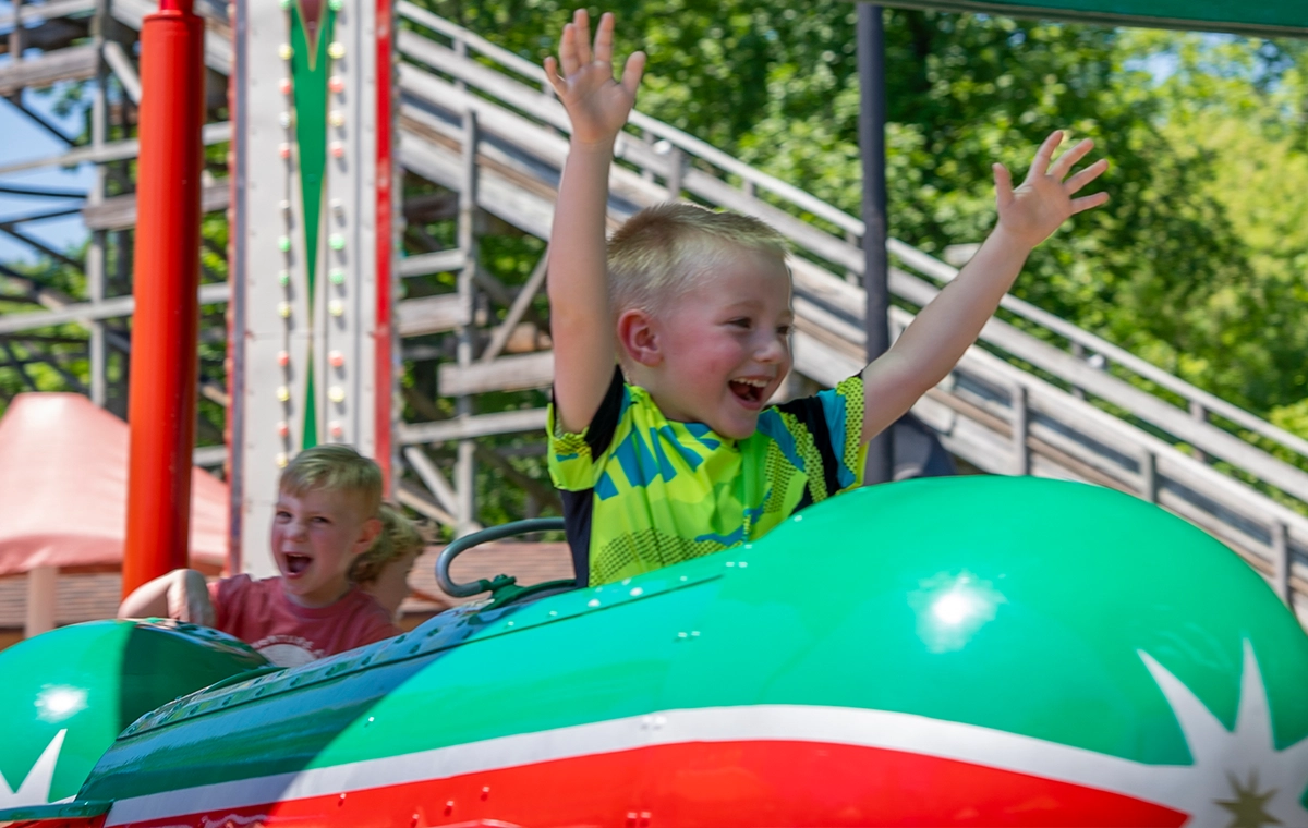 Small boy with his hands up while riding Comet's Rockets at Holiday World & Splashin' Safari in Santa Claus, Indiana.