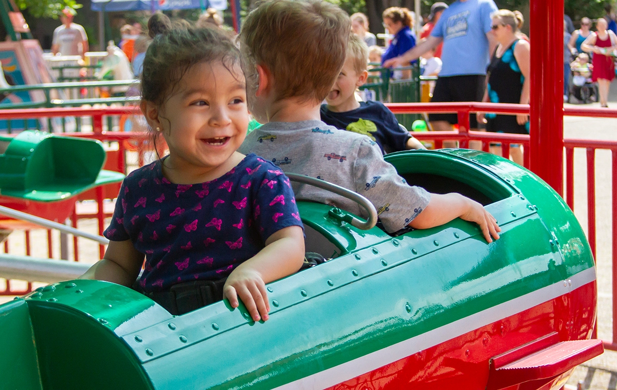 Small girl with a huge grin while riding Comet's Rockets at Holiday World & Splashin' Safari in Santa Claus, Indiana.