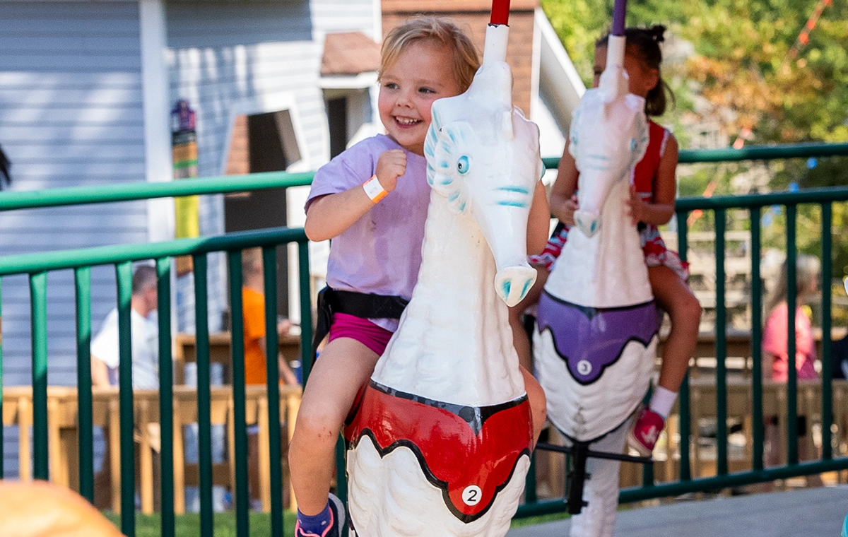 An excited young child riding Dasher's Seahorses at Holiday World & Splashin' Safari in Santa Claus, Indiana.