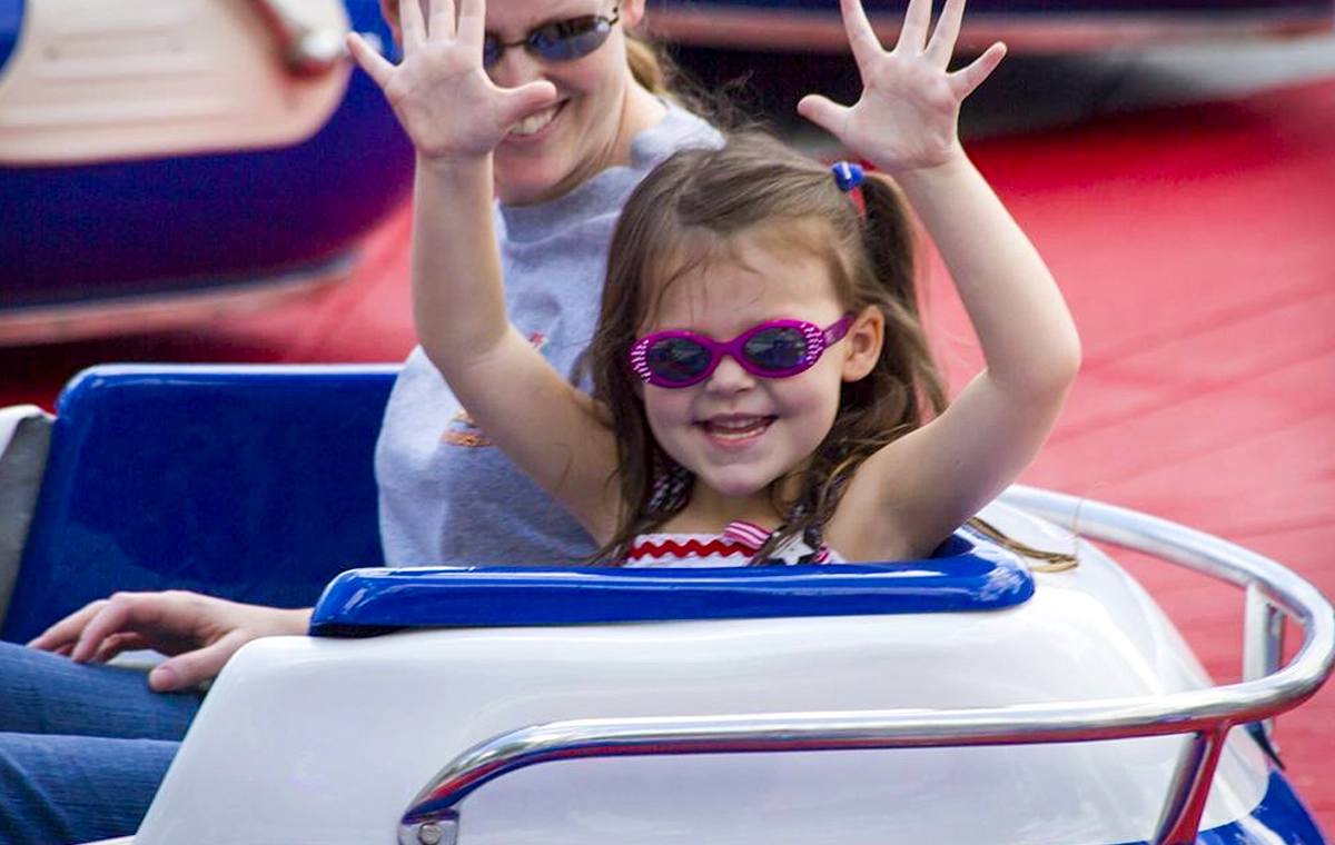 A young girl throws her hands up while riding Firecracker at Holiday World & Splashin' Safari in Santa Claus, Indiana.