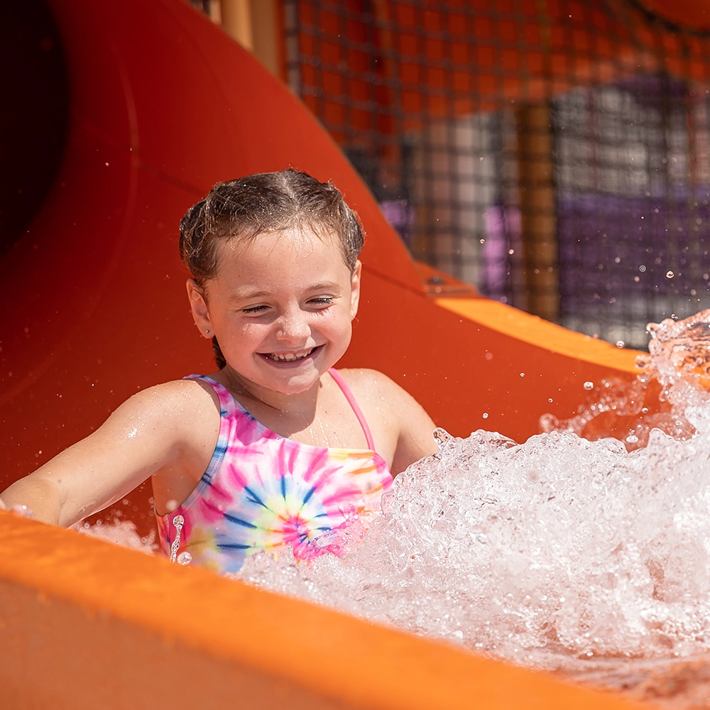 A young girl splashes out of a tube slide at Kima Bay at Holiday World & Splashin' Safari in Santa Claus, Indiana.