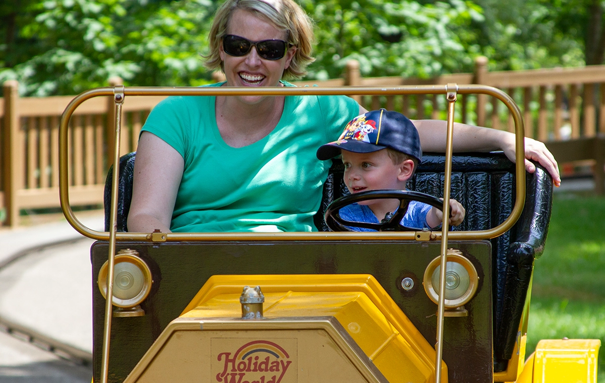 A very young boy takes his mom for a spin on Lewis & Clark Trail at Holiday World & Splashin' Safari in Santa Claus, Indiana.