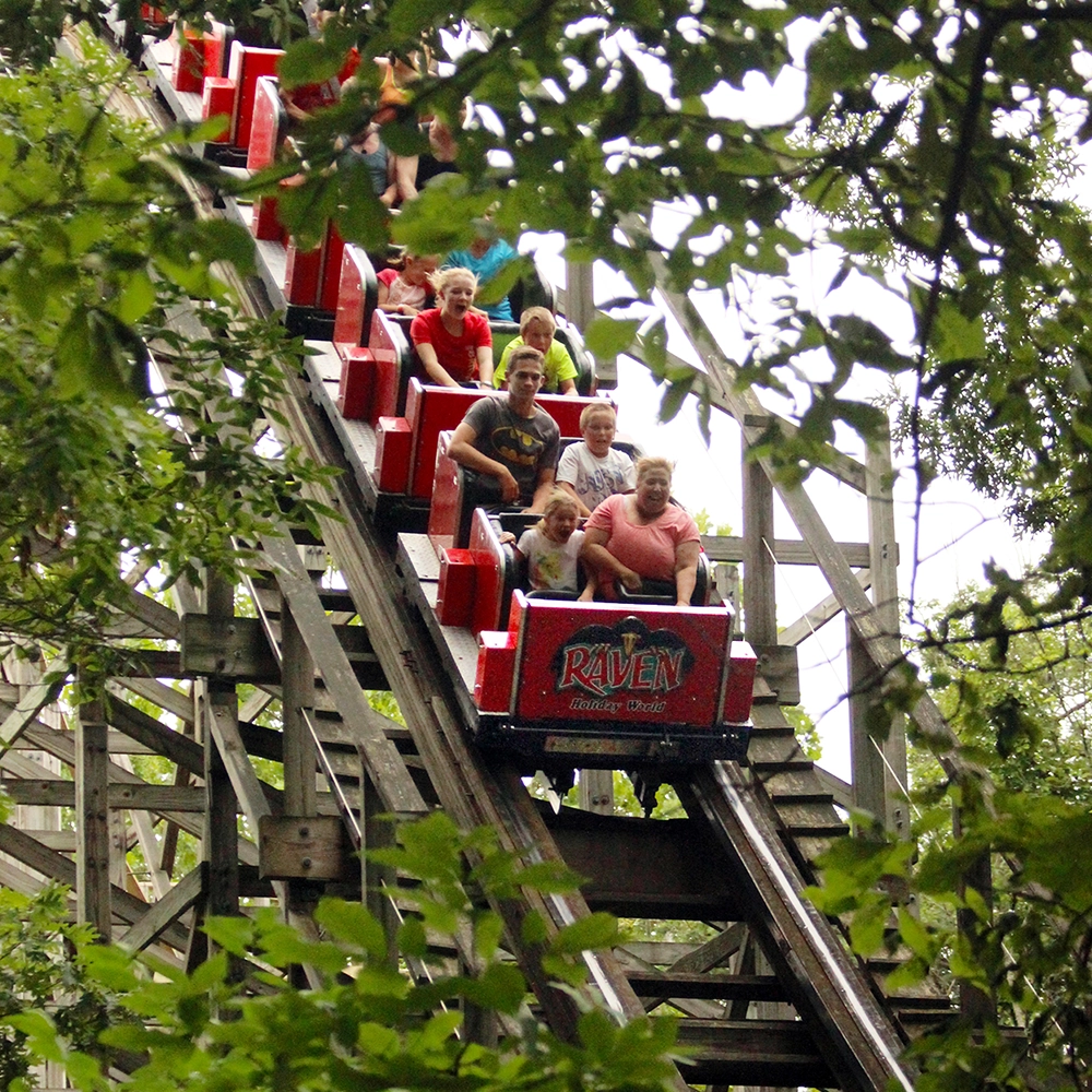 A train traveling downhill through the woods on The Raven at Holiday World & Splashin' Safari in Santa Claus, Indiana