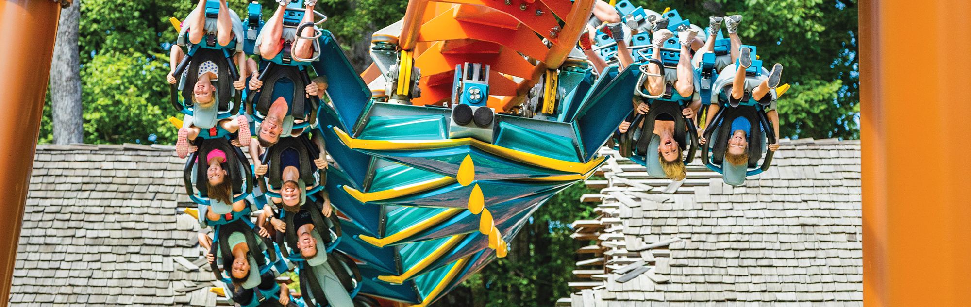 A roller coaster train on Thunderbird goes through an inline roll. You can see riders in all of the visible seats are upside down.
