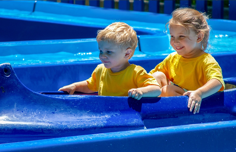 A brother and sister in matching shirts both smile while riding Tippecanoes at Holiday World & Splashin' Safari in Santa Claus, Indiana.