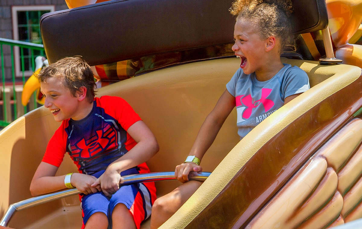 Two young children smile and laugh as they ride Turkey Whirl at Holiday World & Splashin' Safari in Santa Claus, Indiana.