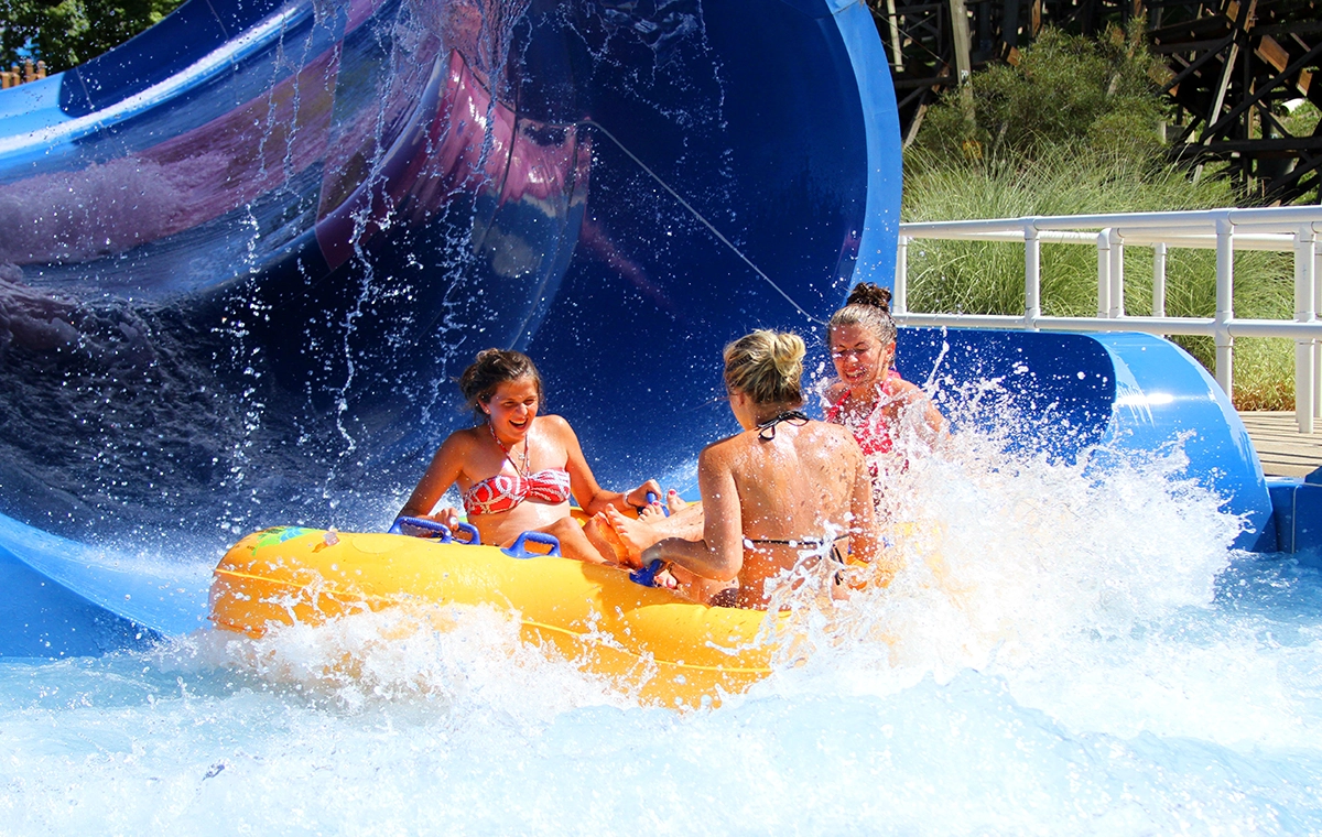 Three women slide into the splash pool of Zinga at Holiday World & Splashin' Safari in Santa Claus, Indiana.