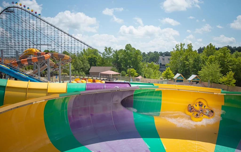Scenic photo of a boat on Bakuli water slide with Cheetah Chase and The Voyage in the background at Holiday World & Splashin' Safari in Santa Claus, Indiana.