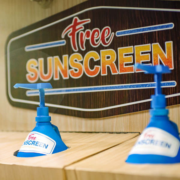 Two free sunscreen pumps in front of a sign that says "Free sunscreen"