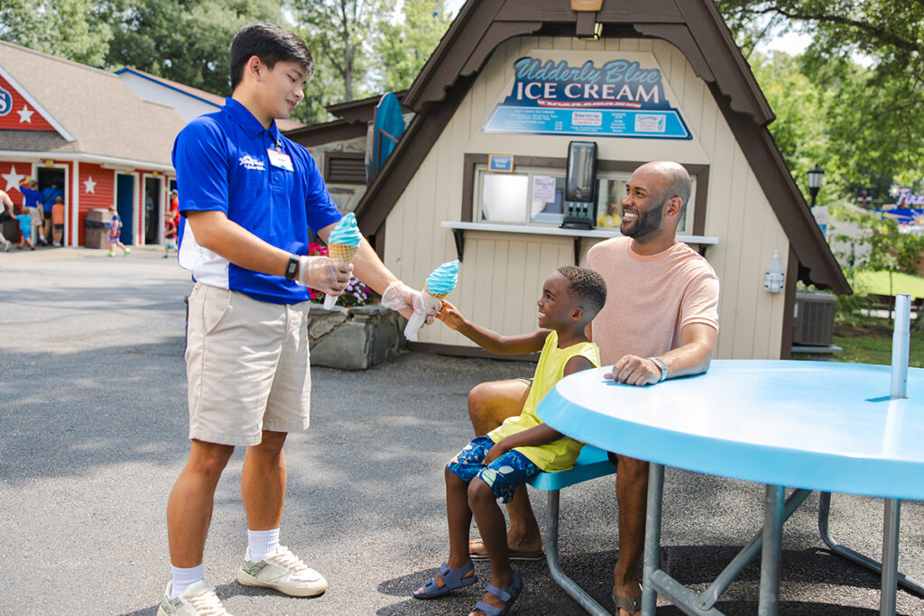 Holiday World Team Member serving Udderly Blue Ice Cream to two Guests at Holiday World & Splashin' Safari