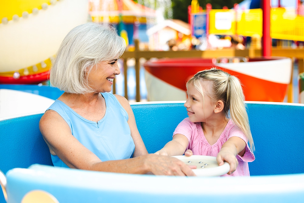 A grandmother and granddaughter smile as they prepare to ride Kitty's Tea Party at Holiday World & Splashin' Safari in Santa Claus, Indiana.