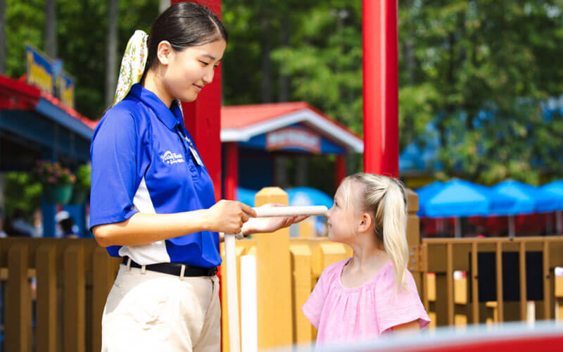 Ride Operator Team Member measuring a child's height in Holidog's Funtown