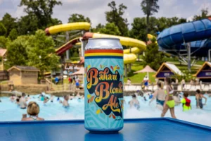 A can of custom-brewed Bahari Blonde Ale in front of Bahari Wave Pool with Wildebeest & Mammoth in the background.