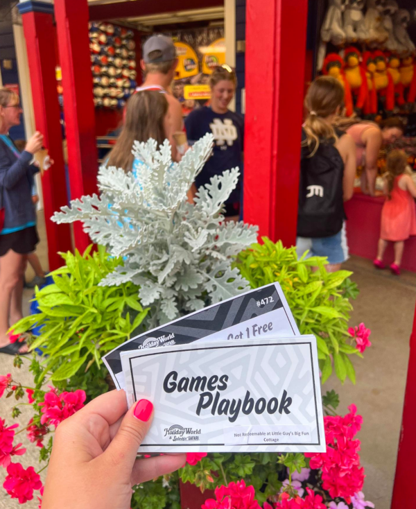 A 2023 Games Playbook is held up in front of games in the 4th of July section of the park.
