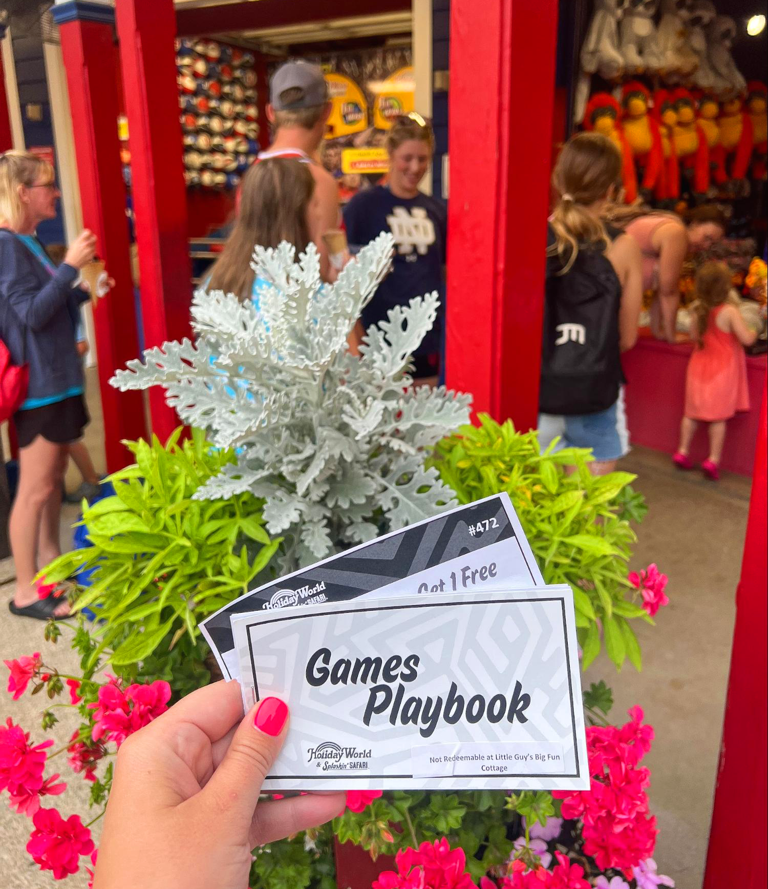 A 2023 Games Playbook is held up in front of games in the 4th of July section of the park.